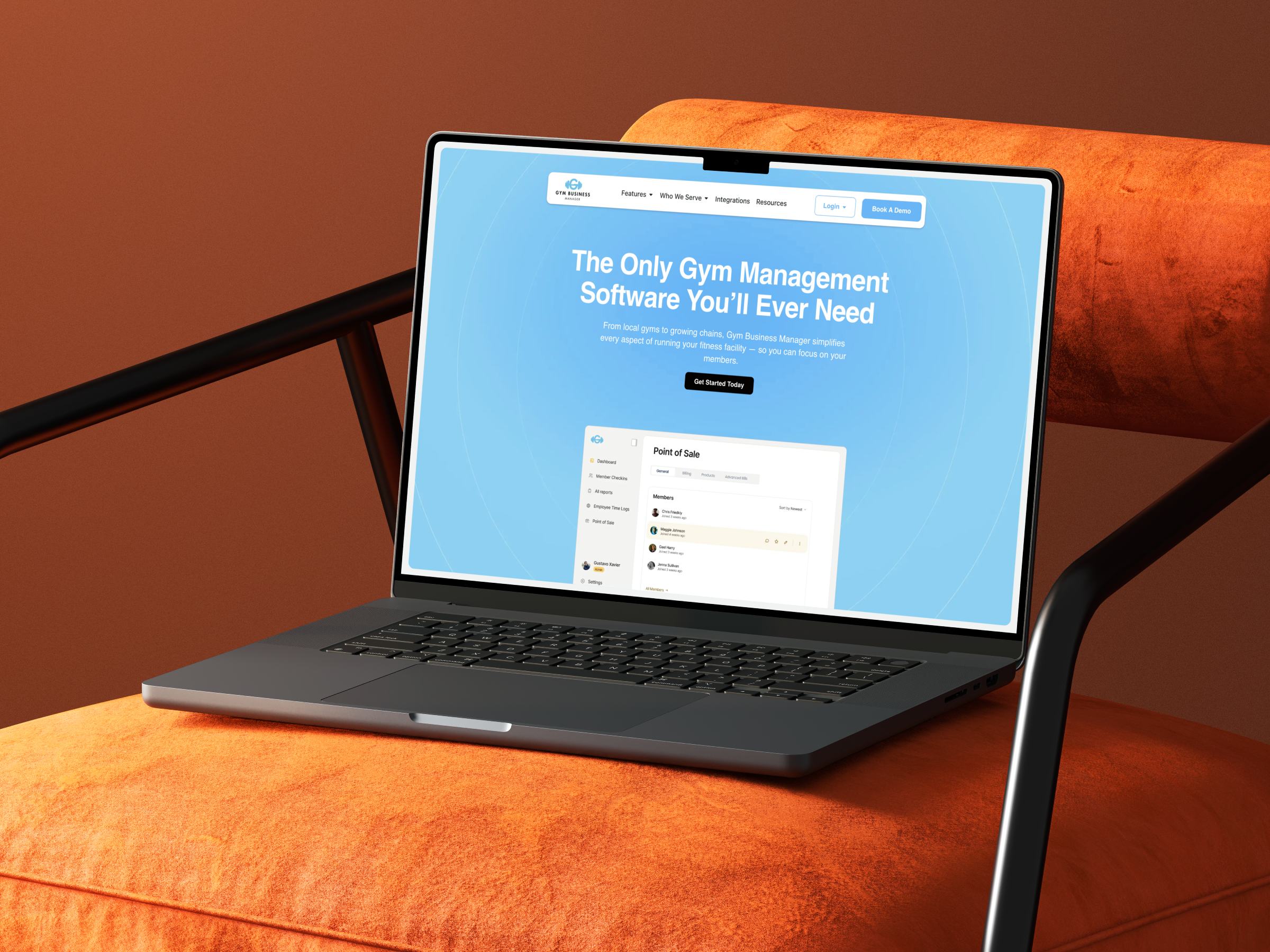 Gym Business Manager website on a laptop resting on an orange armchair.